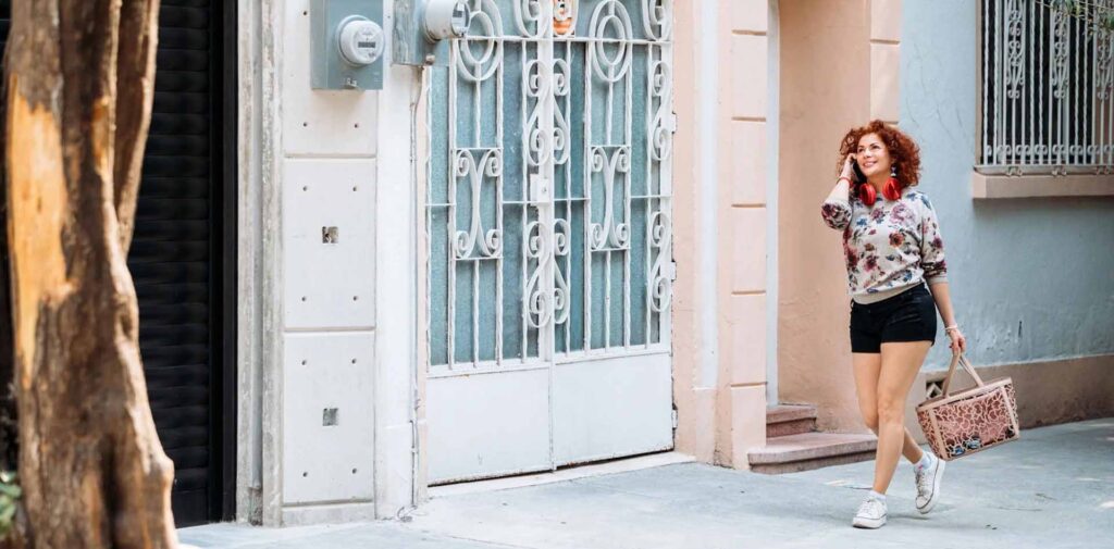 women walking down a sidewalk on the phone